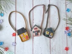 three little houses are hanging from some string