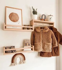 two wooden shelves with clothes hanging on them and a rainbow toy next to the wall