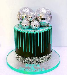 a green and black cake with disco balls on top