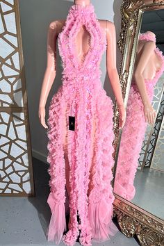 a mannequin wearing a pink dress in front of a mirror