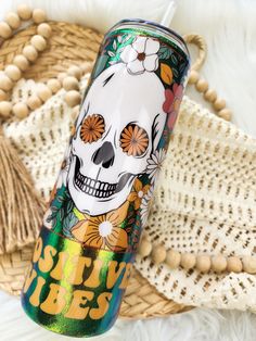 a colorful tumbler with a skull and flowers on it