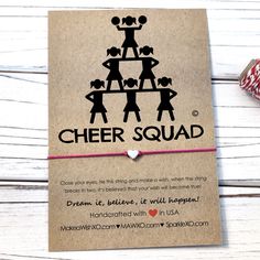 a card with the words cheer squad written on it and a string attached to it