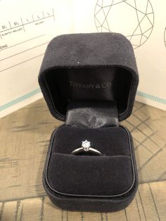 an engagement ring in a black velvet box