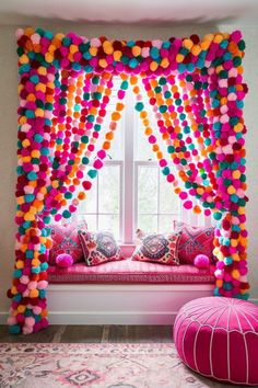 a window seat covered in pom poms