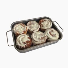 a pan filled with cinnamon rolls covered in icing