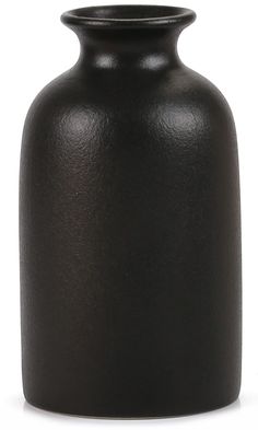 a black vase sitting on top of a white table