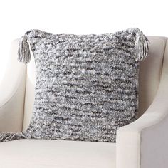 a gray and white pillow sitting on top of a chair