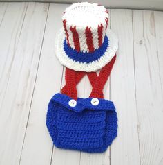 two crocheted items are laying on the floor next to each other and one has a red white and blue hat