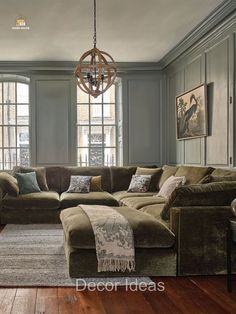 a living room filled with lots of furniture next to two windows and a chandelier hanging from the ceiling