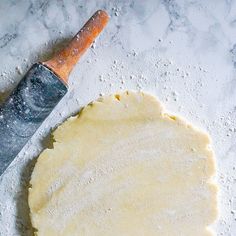 an uncooked pizza dough next to a knife