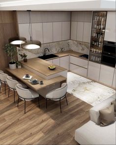 an aerial view of a kitchen and dining room with wood flooring, white walls and cabinets