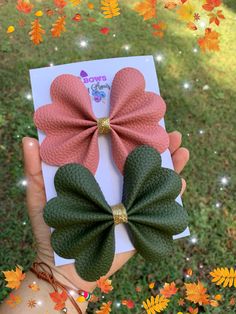 two pink and green hair bows on top of each other in front of fall leaves