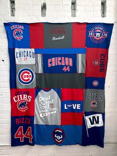 a chicago cubs baseball jersey quilt hanging on a brick wall