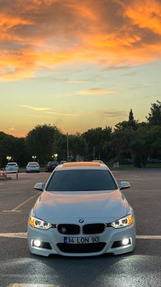 a white car parked in a parking lot at sunset