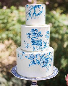 a three tiered cake with blue flowers on it