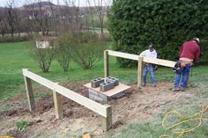 two men are working on building a fire pit