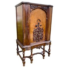 an old fashioned wooden cabinet with carvings on the front and sides, sitting against a white background