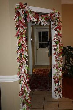 a hallway decorated for christmas with ribbons and bows on the front door, along with potted plants