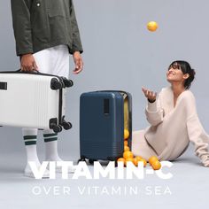 a woman sitting on the ground next to two suitcases with oranges in front of her