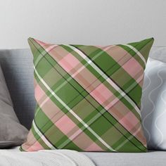 a green and pink plaid pillow sitting on top of a couch