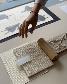 a person reaching for something on top of a wooden block with a rubber stamper