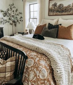 a cat is laying on top of a bed in a room with white walls and windows