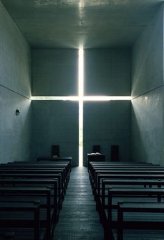 the inside of a church with rows of pews in front of a large cross