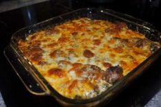 a casserole dish with meatballs and cheese in it sitting on a counter