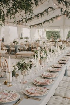 a long table set with plates and candles