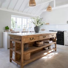 a large kitchen island in the middle of a room with white walls and ceilinging