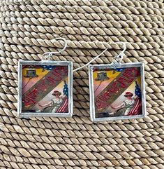 two square earrings with an image of a man on the front and back of them