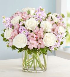 a glass vase filled with white and pink flowers