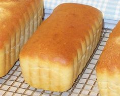 four loaves of bread sitting on a cooling rack