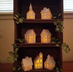 some paper houses are sitting on a shelf