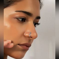 a woman with nose piercings on her nose and nose ring in front of her face