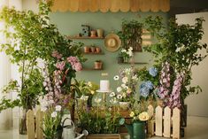 a room filled with lots of different types of flowers and plants on shelves next to each other