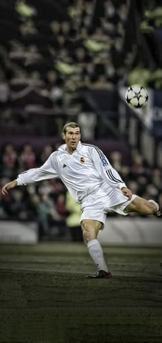 a man kicking a soccer ball on top of a field