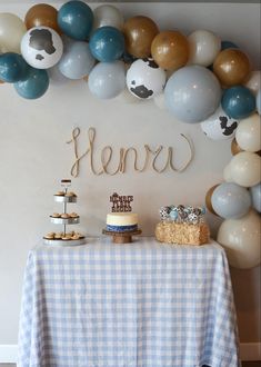 a table topped with cake and desserts next to balloons