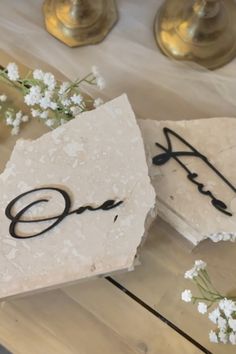 Acrylic clear bases, travertine, and black acrylic lettering. Stone Seating Chart, Fabric Table Numbers, Rock Table Numbers, Diy Table Numbers Wedding