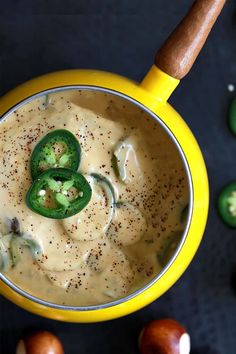 mexican beer cheese fondue with jalapenos on the side in a yellow bowl