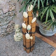 a group of vases sitting on top of a wooden pole next to a statue