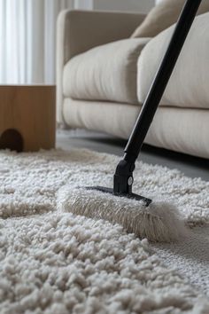 a mop is laying on the floor in front of a couch