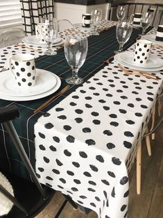 the table is set with black and white polka dot napkins, glasses, and plates