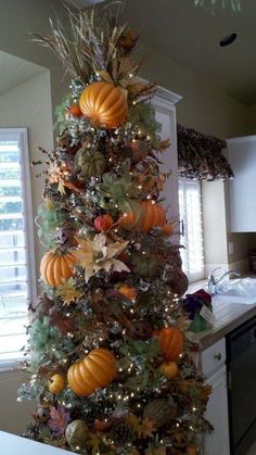 a decorated christmas tree with pumpkins and leaves