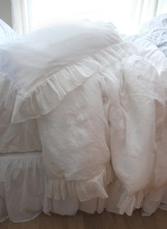 white ruffled bedspread and pillows on a bed