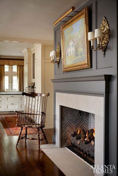 a living room filled with furniture and a fire place in front of a painting on the wall