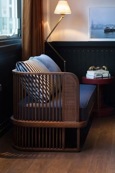 a living room with a couch, table and lamp on the side by the window