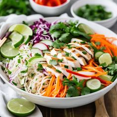 a white bowl filled with chicken and veggies on top of a wooden table