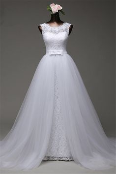 a white wedding dress on display in front of a gray background