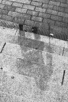 a black and white photo of a manhole cover on the ground next to a street